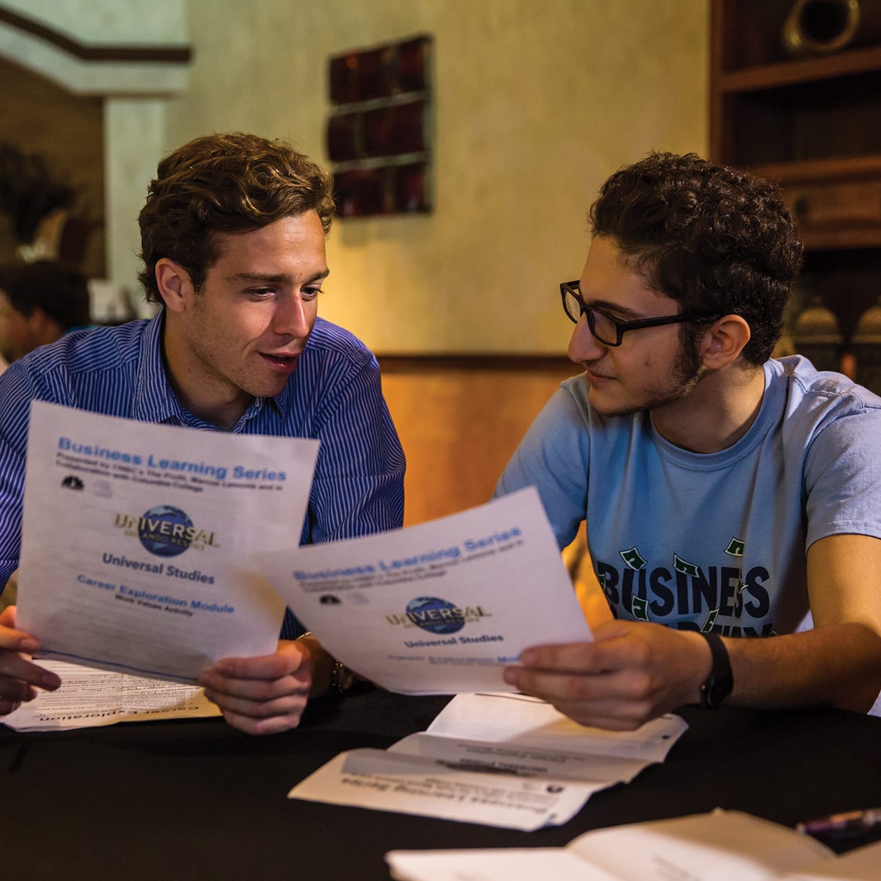 Two students looking over the Business Learning Series paperwork in a Universal Orlando class.