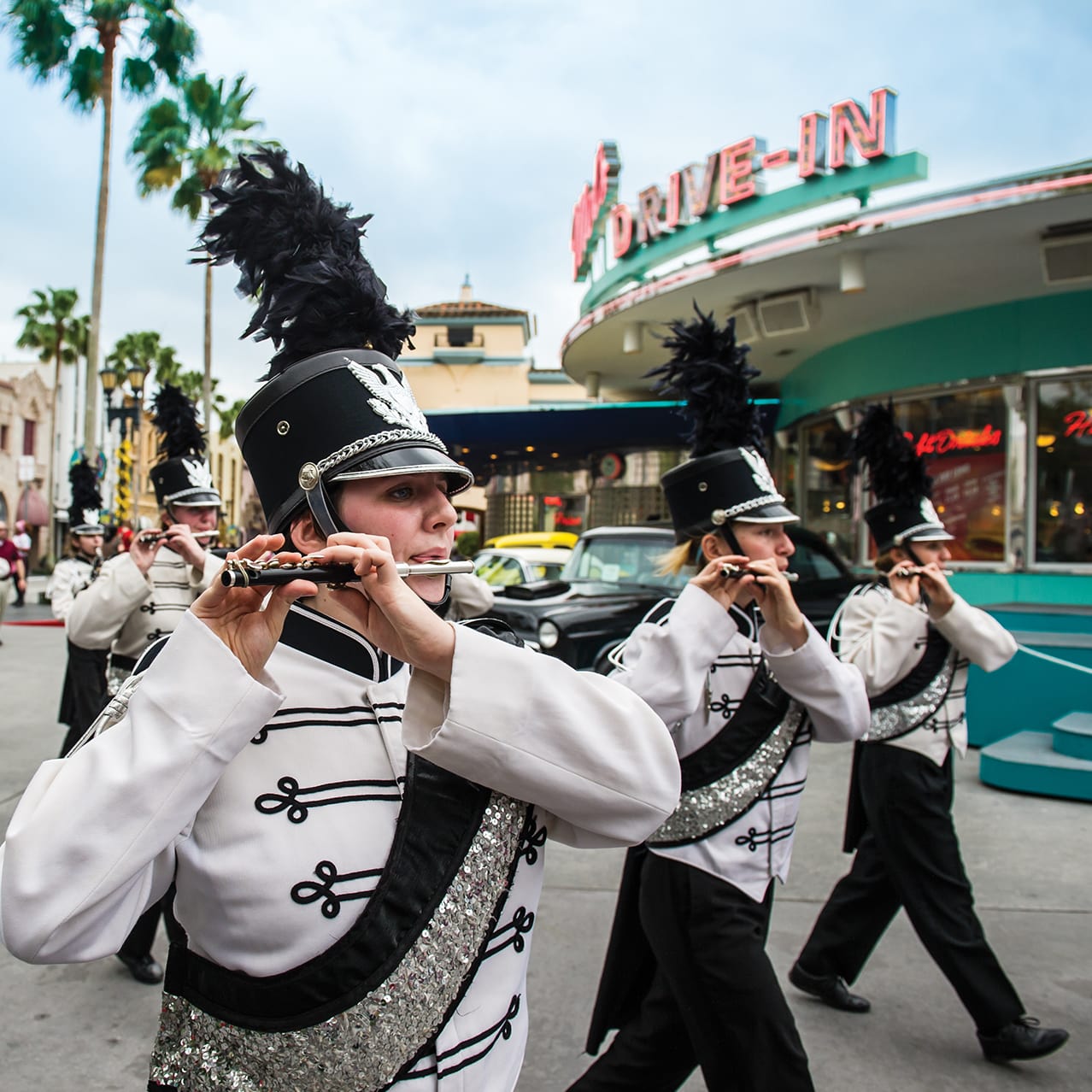 A high school marching band moving past Mel’s Drive In at Universal Studios Florida.