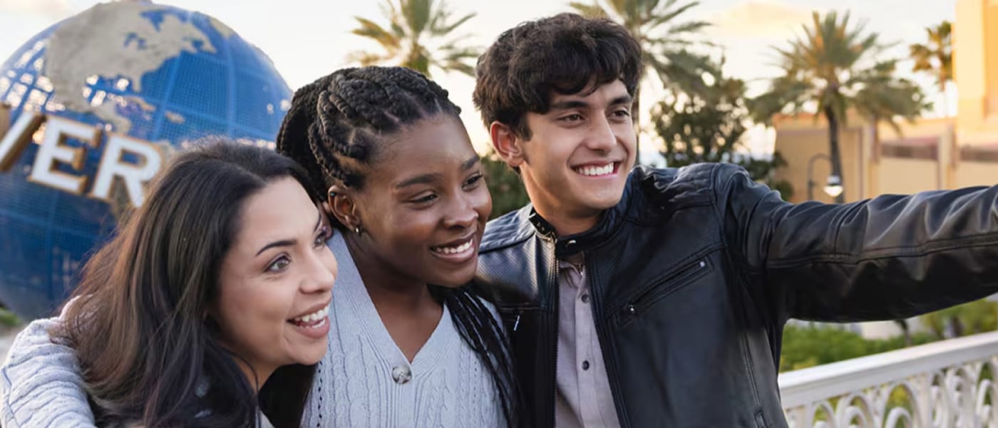 Youth pose near the globe for a selfie