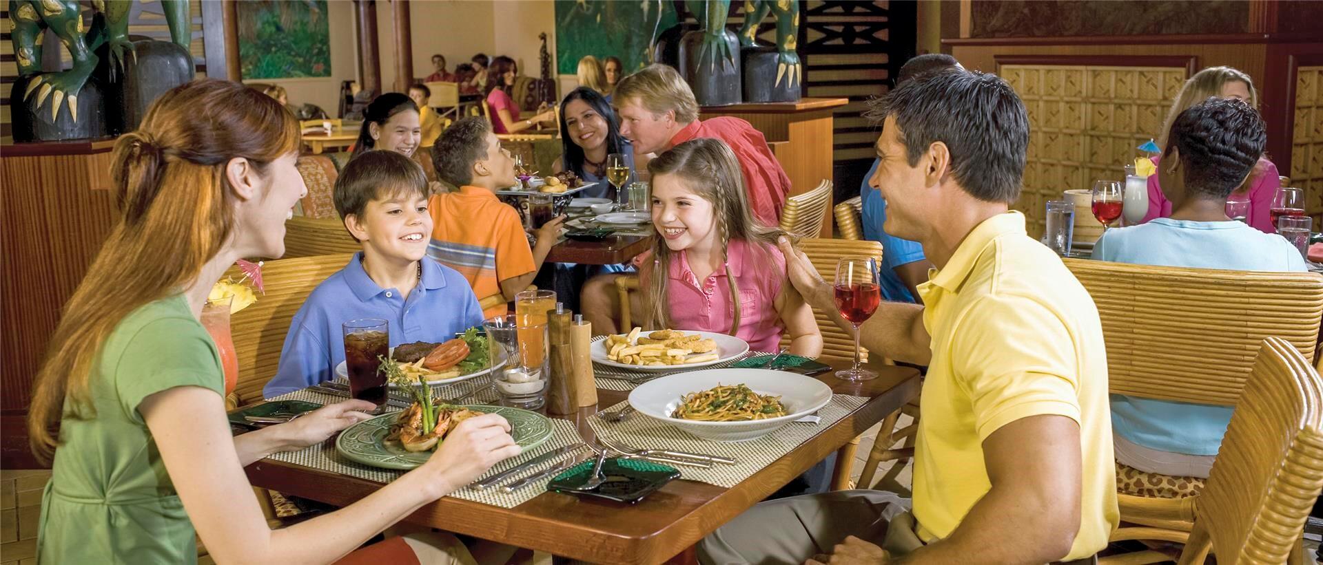 two parents and two children sit together for dinner at islands dining room at loews royal - Islands Dining Room two parents and two children sit together for dinner at islands dining room at loews royal - Islands Dining Room