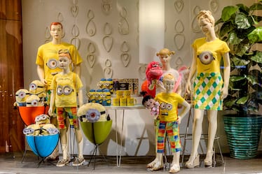 A window display shows a mannequin family with Minion themed merchandise at the Universal Orlando Resort Store inside Cabana Bay Beach Resort.