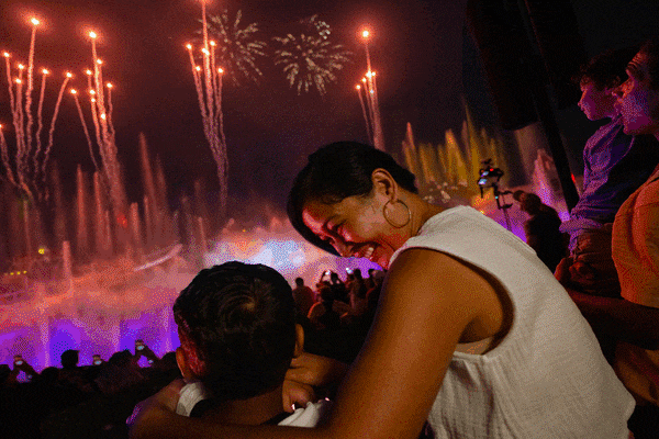 Gif of mother and daughter watching fireworks, two women on Velociocaster, and a mother and son watching the Mega Movie Parade featuring a Jaws float