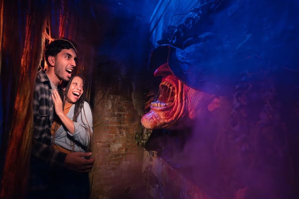 Two guests walking through a Halloween Horror Nights haunted house.