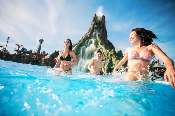 Group of young adults running through pool at Universal Volcano Bay