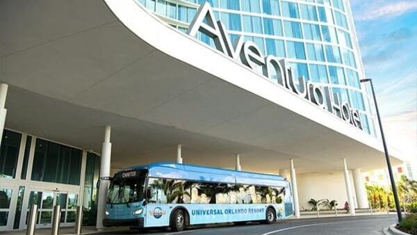 A Universal hotel shuttle bus in front of Universal Stella Nova Resort.