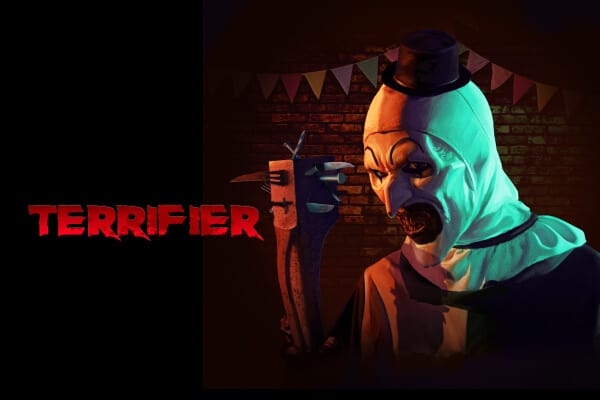 Art the Clown holding a club enhanced with sharp tools and utensils, in front of a brick wall with party flags, next to the word 