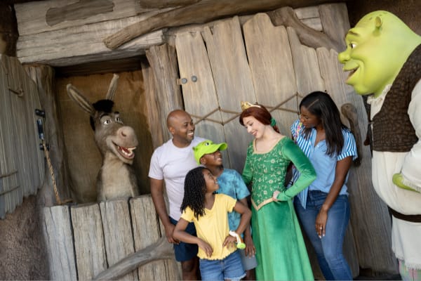 A family meet Shrek, Fiona and Donkey outside of Shrek's cottage at Shrek's Swamp Meet in DreamWorks Land at Universal Studios Florida. 