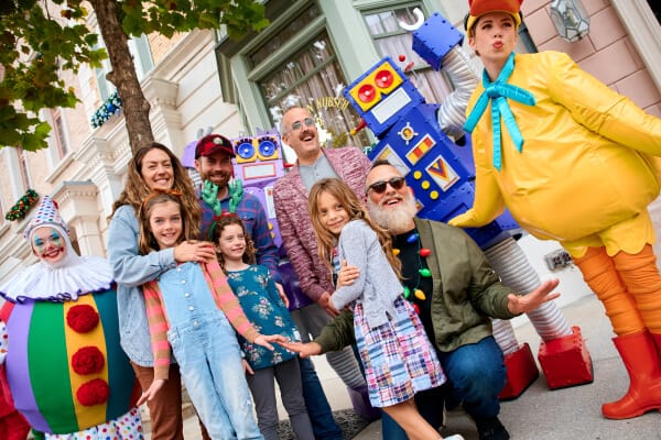 A family posing with robots and characters dressed up for Universal s Holiday Parade featuring Macy's.