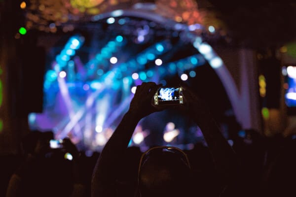 Concert attendees hold up their phones to capture the show.