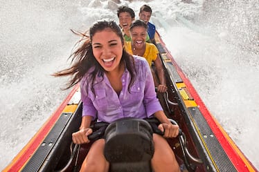 A group of young adults splashes through Dudley Do Right's Ripsaw Falls at Universal Orlando's Toon Lagoon.