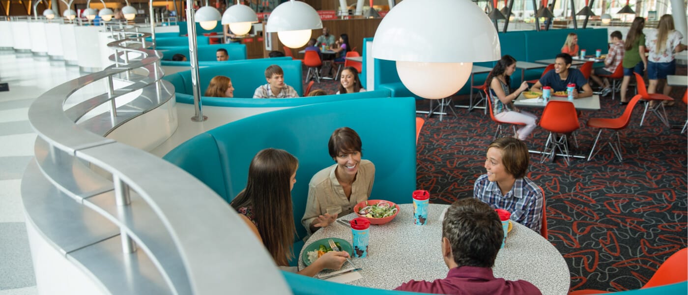 Guests dine in the bold blue booths of the retro Bayliner Diner at Universal's Cabana Bay Beach Resort.