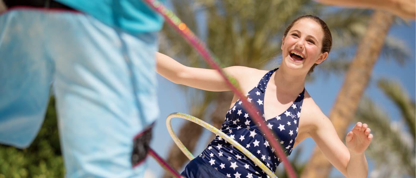 Two children hula hoop by the pool at Cabana Bay Beach Resort in Universal Orlando.