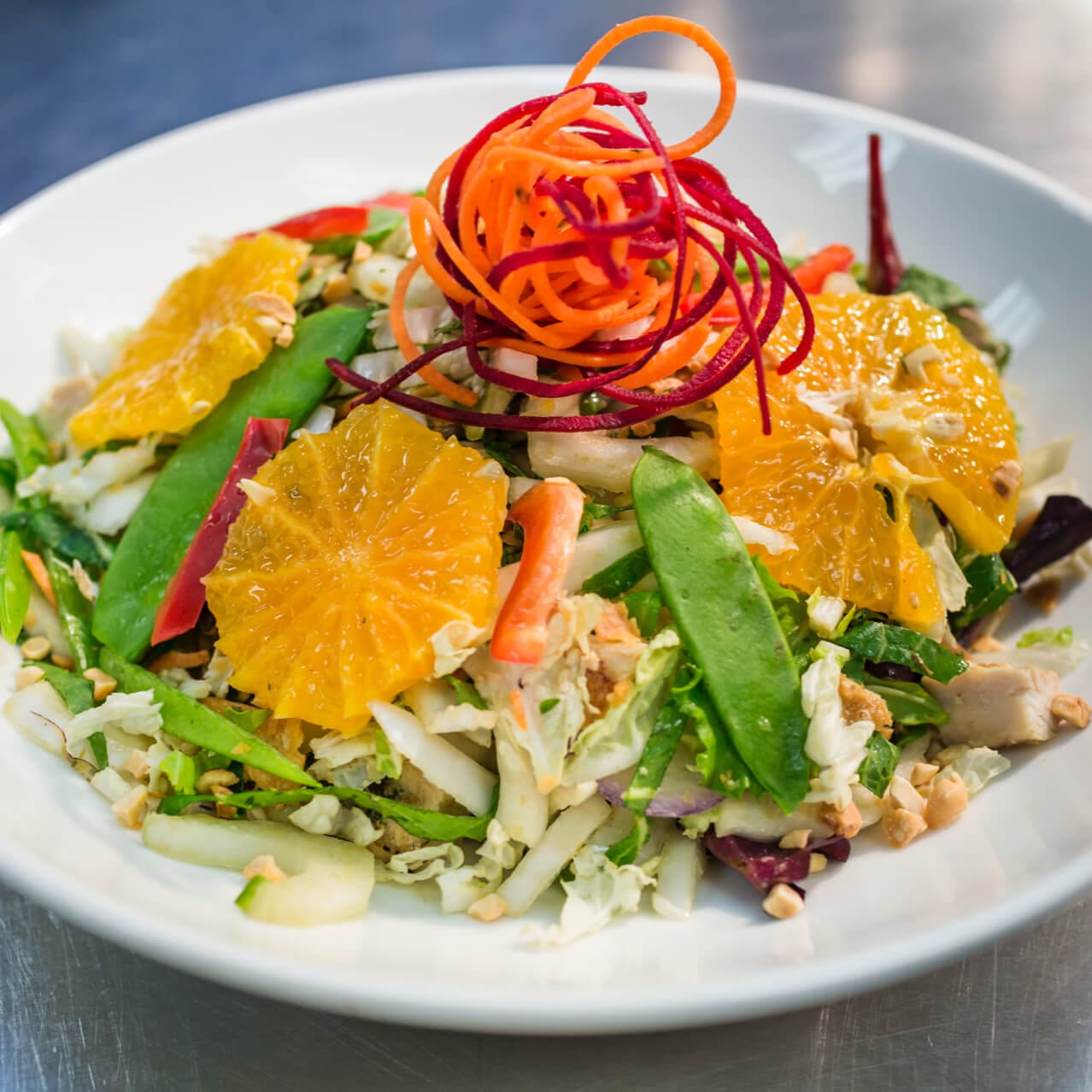 A colorful Asian dish at Universal CityWalk's Cowfish Sushi Burger Bar topped with mandarin oranges and snow peas.