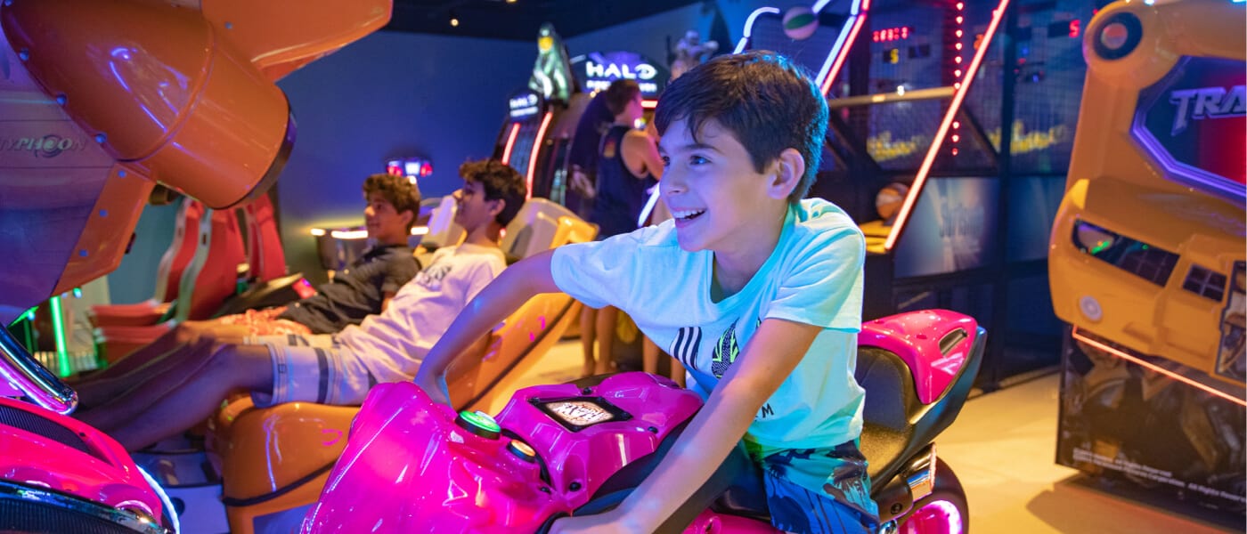 A child enjoys a game within Surfside Inn and Suites' game room.