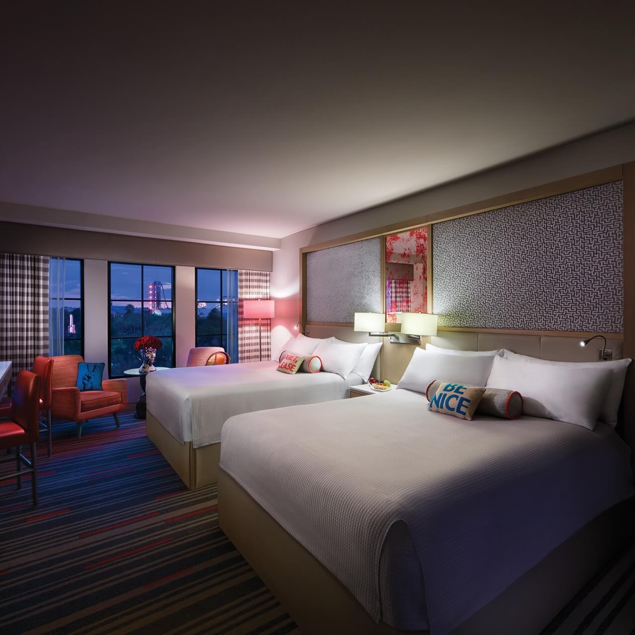A nighttime interior view of a Guest Room with two Queen beds at Hard Rock hotel in Universal Orlando. 