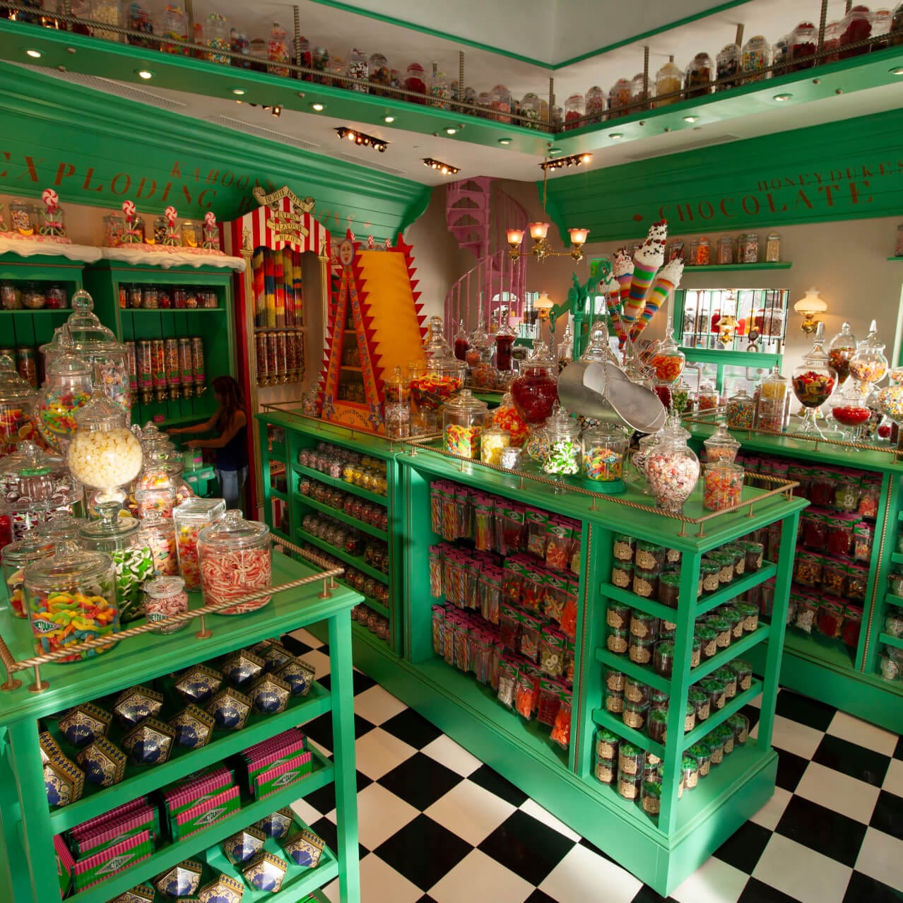 Green shelves filled with candy inside of Honeydukes Candy Shop.