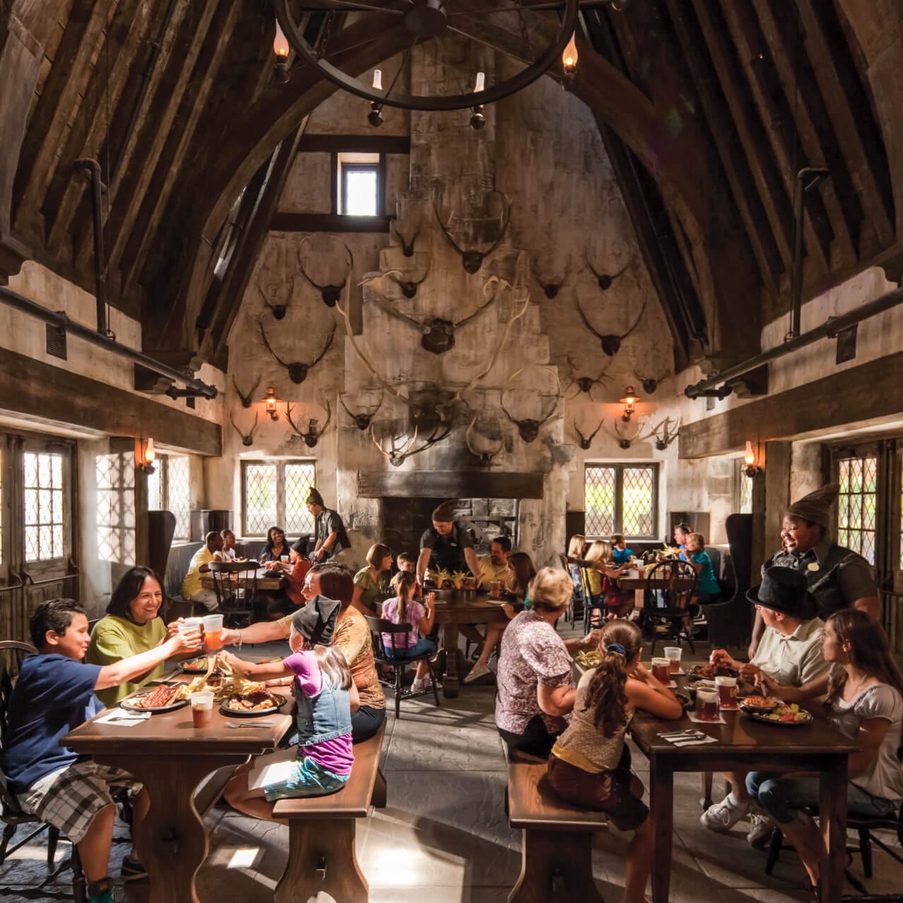 Guests admiring the decor of the Three Broomsticks restaurant in The Wizarding World of Harry Potter Hogsmeade at Universal's Islands of Adventure.