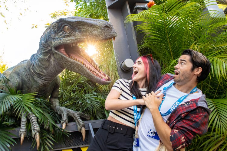 A Universal Orlando Annual Passholder couple reacts as Blue the Velociraptor jumps out and bares her teeth in a Paddock at Universal Islands of Adventure.