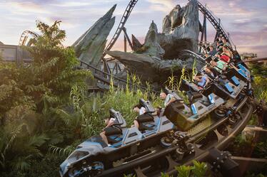 Thrilled riders zoom along the track on Jurassic World Velocicoaster.