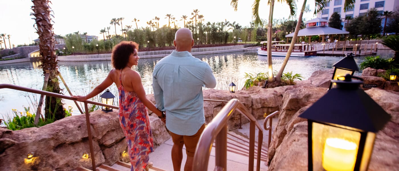 Two guests of Loews Sapphire Falls Resort are strolling along the resort's walking path.