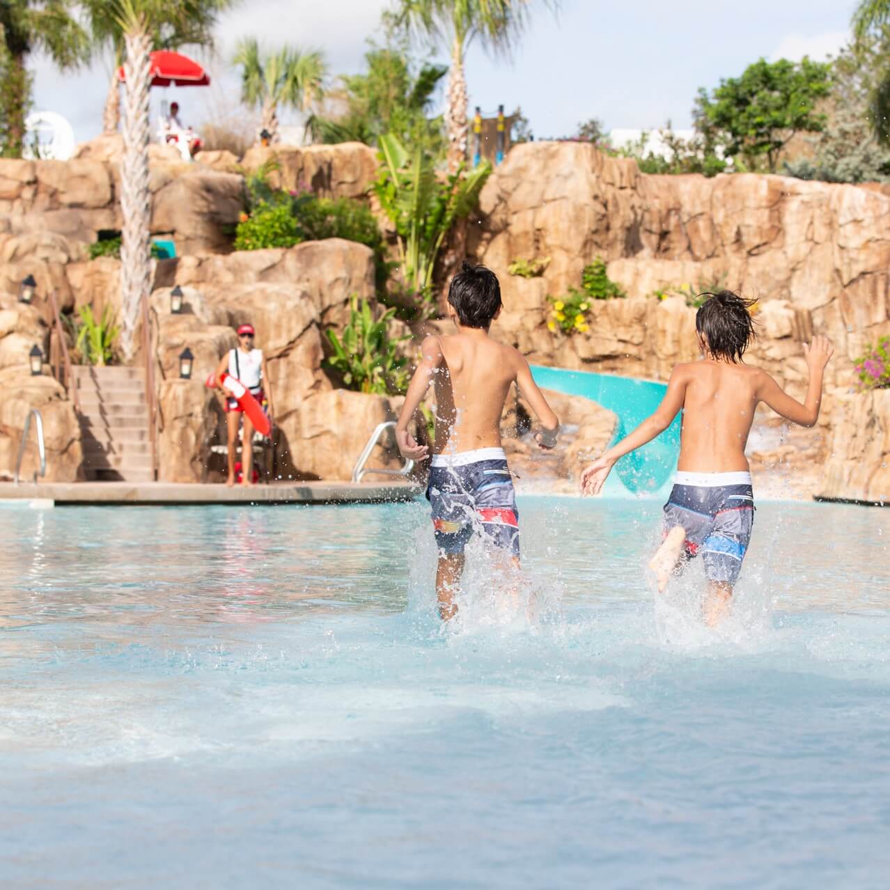 Two kids splash into the zero entry swimming pool at Loews Sapphire Falls Resort, an on site hotel at Universal Orlando Resort. 