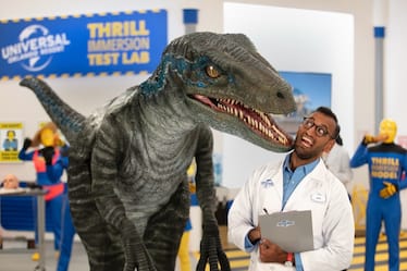 Thrills researcher Alex stands at the front of the Universal Orlando Thrills Immersion Test Lab next to Blue the Raptor.