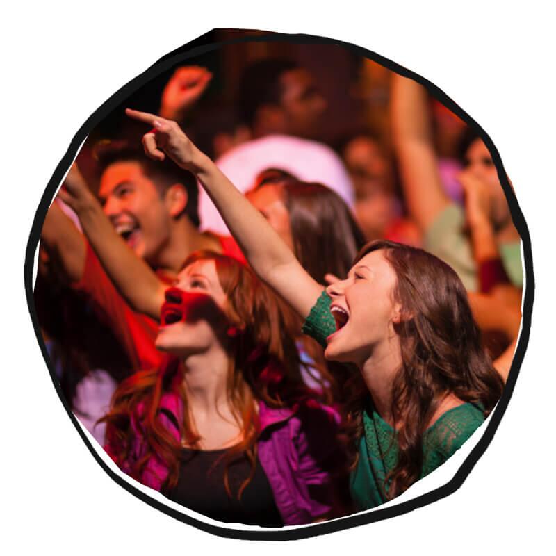 Girls in a crowd point upwards and sing together.