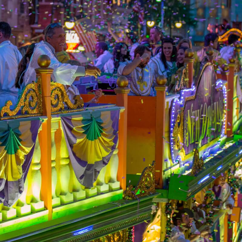 Guests throw beads to the crowd from atop a parade ﬂoat at Universal's Mardi Gras: International Flavors of Carnival.