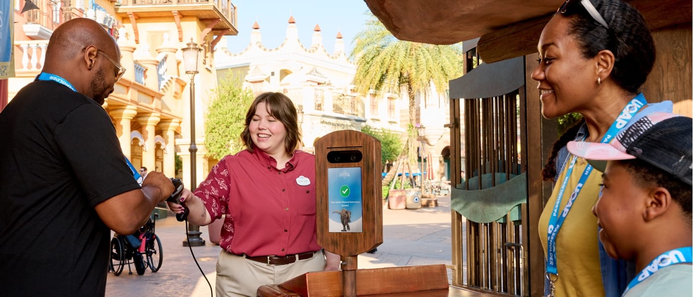 Mother and son watch as Dad uses Photo Validation with his mobile phone to entry the park.