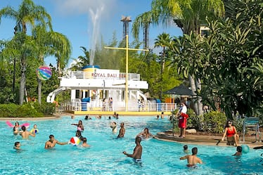 Guests splash and play in the lagoon style swimming pool, complete with a children's area and water cannons, at Loews Royal Pacific Resort at Universal Orlando. 