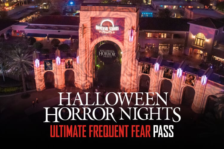 Bird’s eye nighttime view of Universal Studios Florida arches with a circular Halloween Horror Nights banner in the middle and the park illuminated behind. 