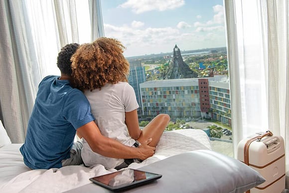 A couple looks out their Universal Orlando hotel window at the Volcano Bay.