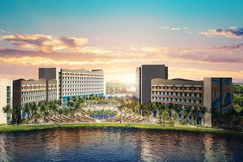 An artistic rendering of Universal's Endless Summer Resort - Surfside Inn and Suites shows a large hotel complex alongside the water with some sailboats going by.