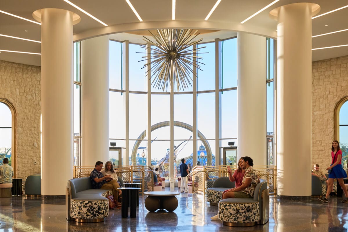 Universal Helios Grand Hotel, a Loews Hotel, lobby and lounge area, with spacious seating and floor-to-ceiling views of Universal Epic Universe. 
