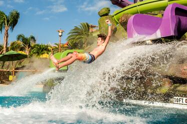 A guy flies out into the air as he comes off the Ohno Drop Slide at Universal's Volcano Bay.