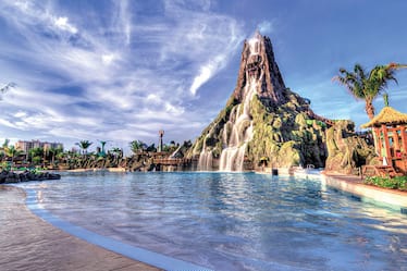 A picturesque view of a lagoon and water rushing down the volcano at Universal's Volcano Bay water theme park.