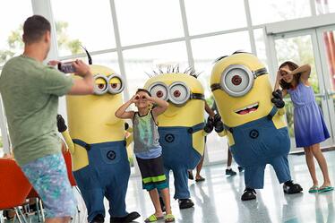 Conoce a unos de tus personajes favoritos de los parques temáticos en Universal Orlando's Cabana Bay Beach Resort. Dos hermanos posan junto a tres Minions de la película Despicable Me mientras su padre les toma una foto en Universal's Cabana Bay Beach Resort, en Orlando.